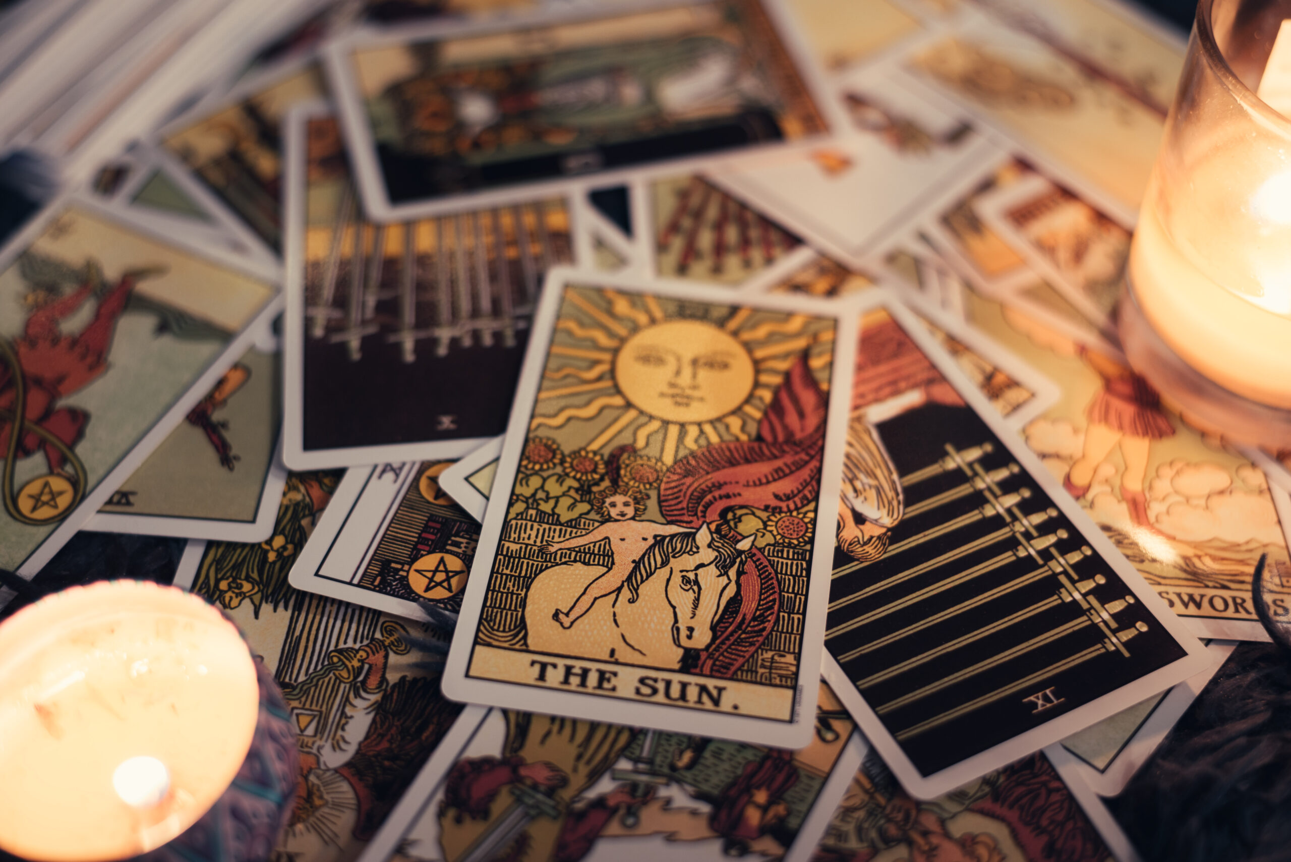 Tarot cards. THE SUN card on tarot cards with candles. Astrologists and fortune teller concept.